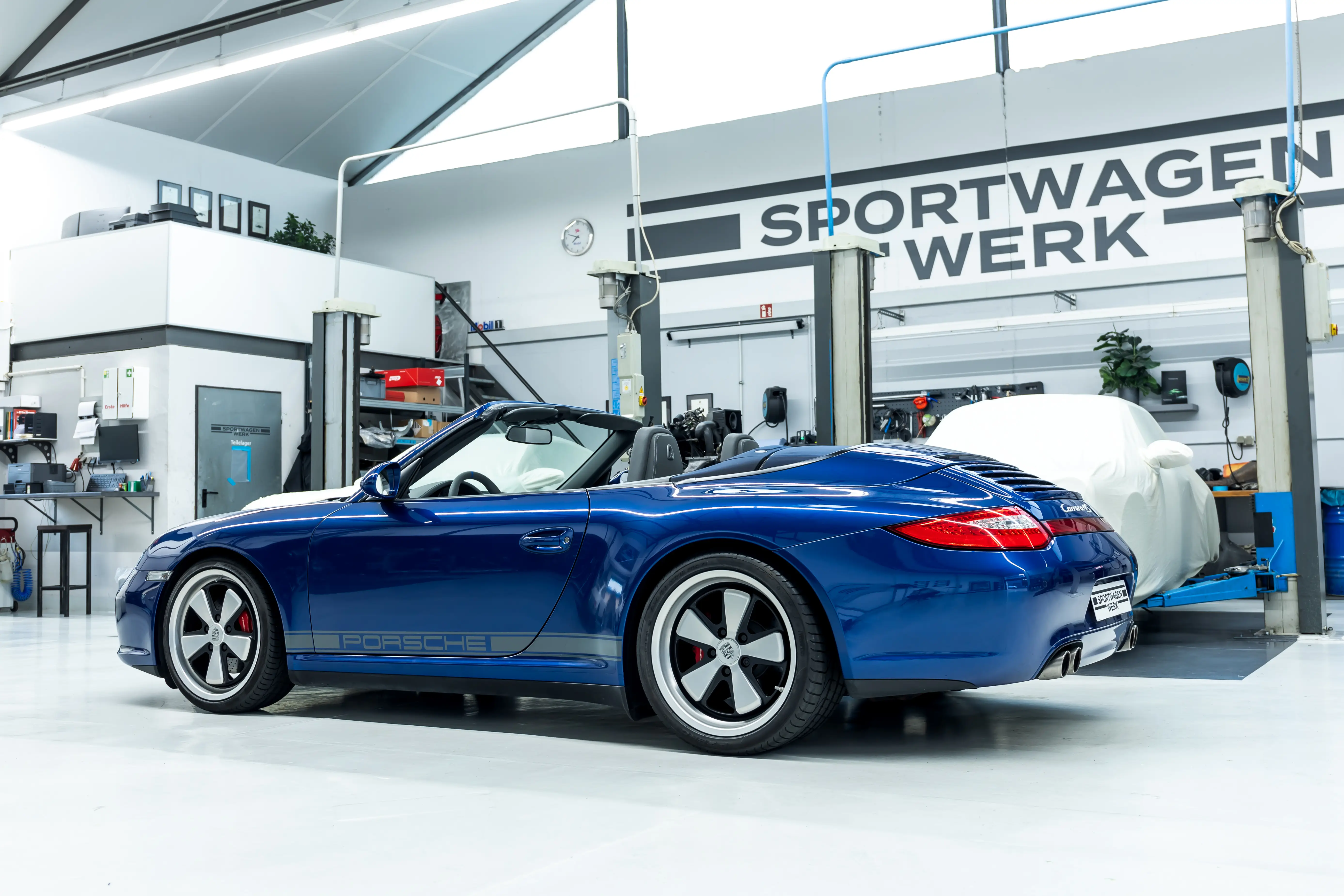 Porsche 997 Carrera 4S Aquamarin Heckansicht offen bei Sportwagen Werk Neuss