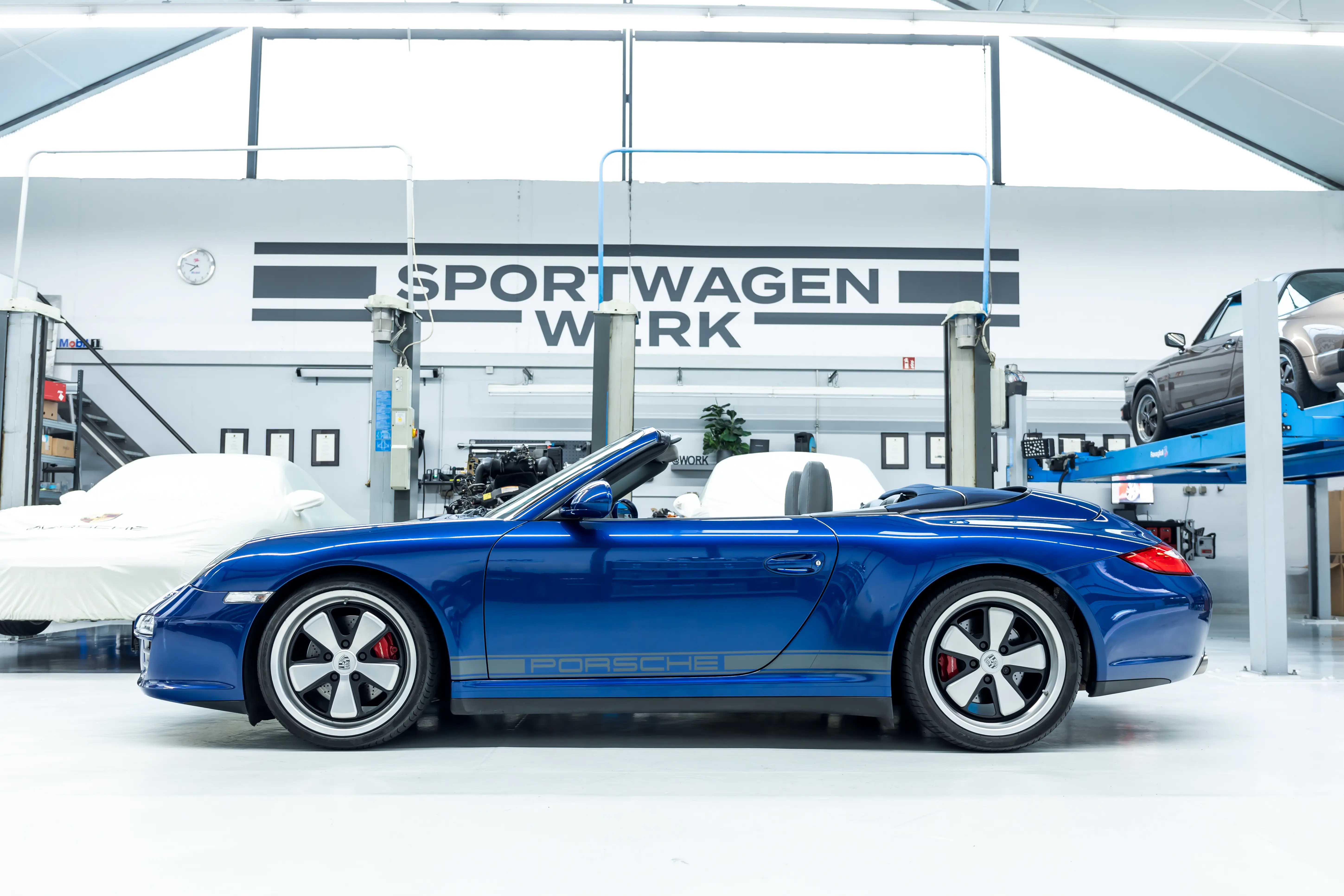 Porsche 997 Carrera 4S Aquamarin Seitenansicht mit Porsche-Schriftzug bei Sportwagen Werk