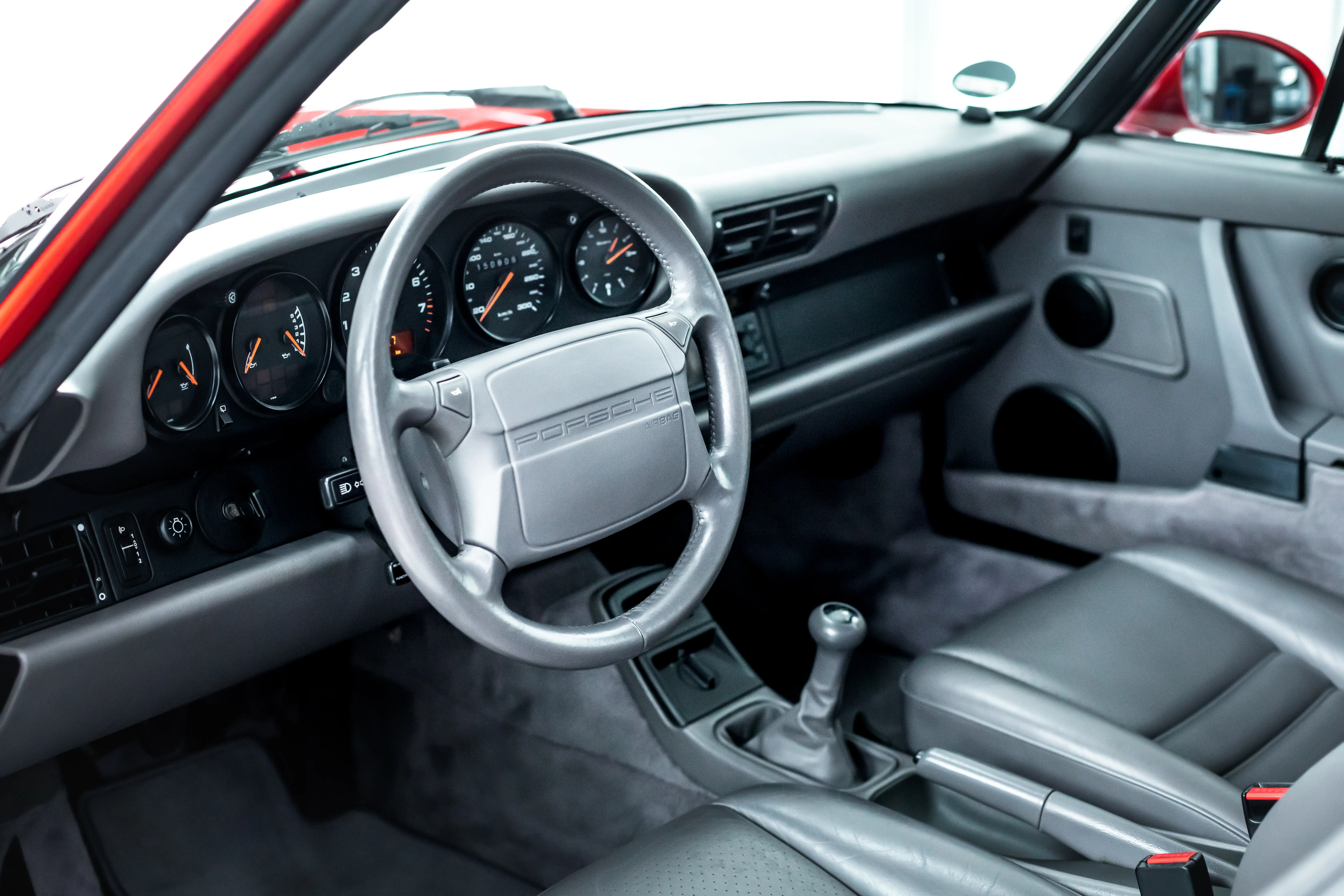 Cockpit des Porsche 964 Carrera 2 mit Porsche-Lenkrad, Schaltgetriebe und grauem Lederinterieur