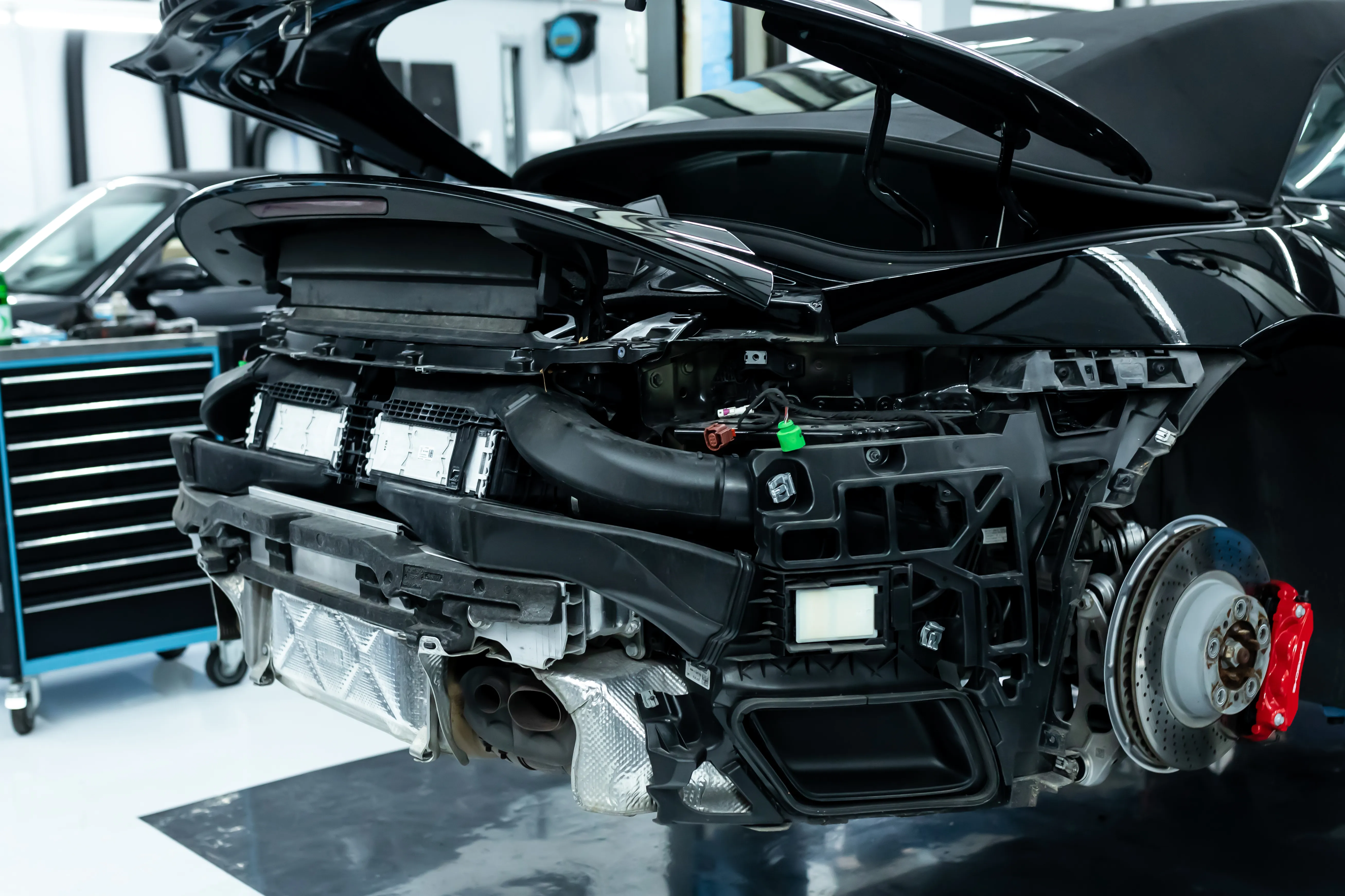 Porsche 911 Turbo Heck komplett demontiert mit freiliegendem Steuergerät, Auspuffanlage und rotem Bremssattel