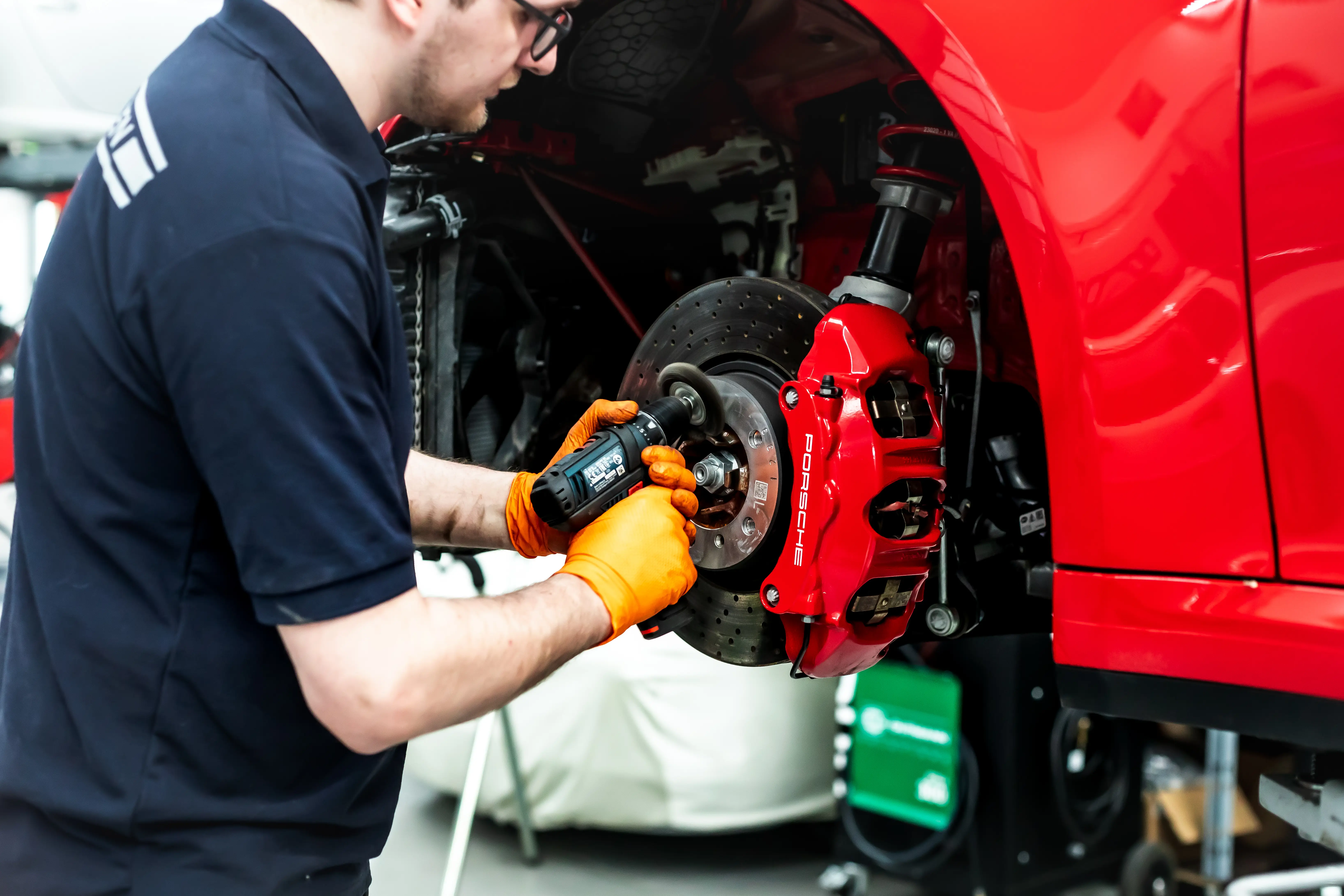 Sportwagen Werk Techniker montiert Bremsscheibe am Porsche 992 Rubin