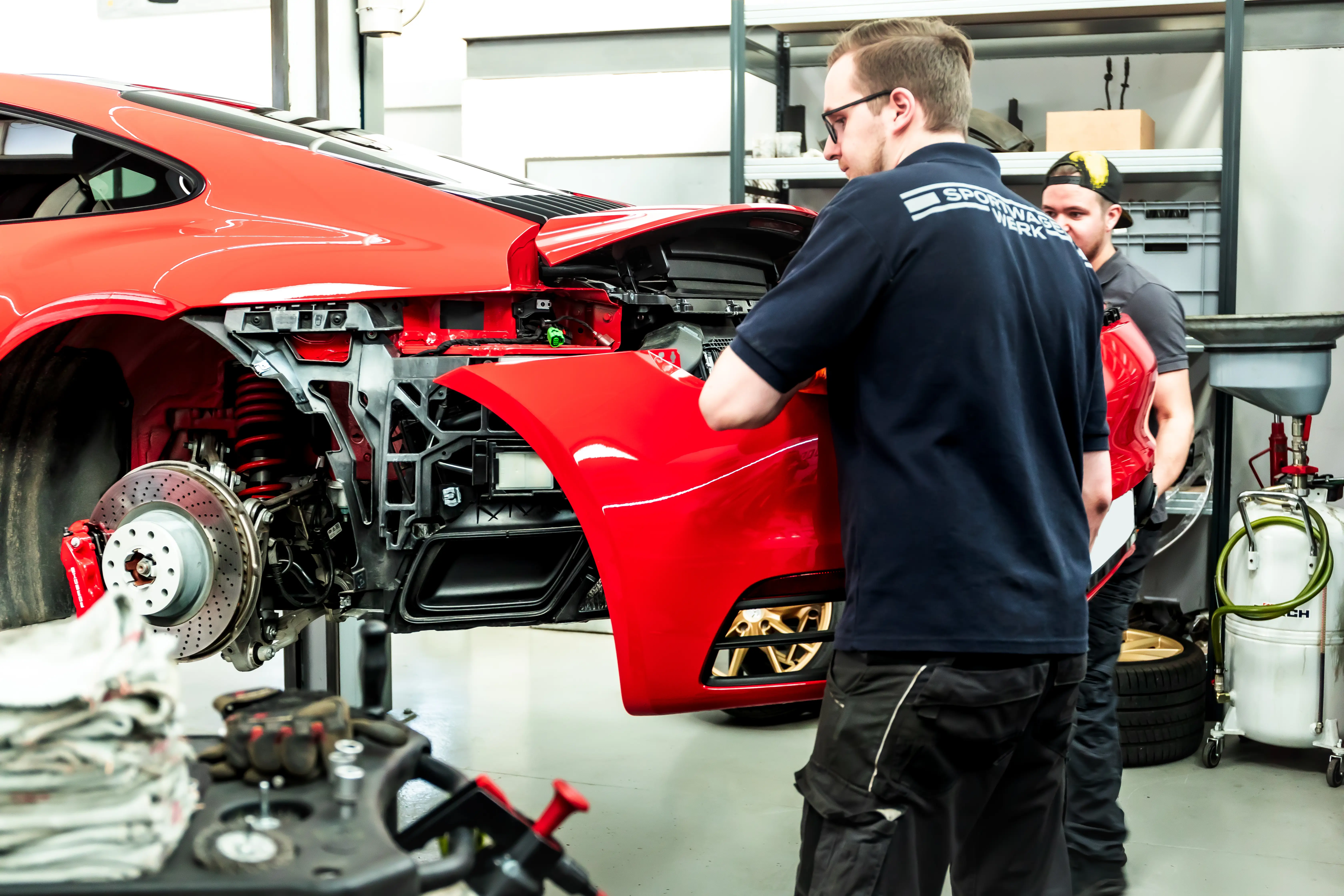 Sportwagen Werk Team demontiert Heckschürze des Porsche 992 Rubin