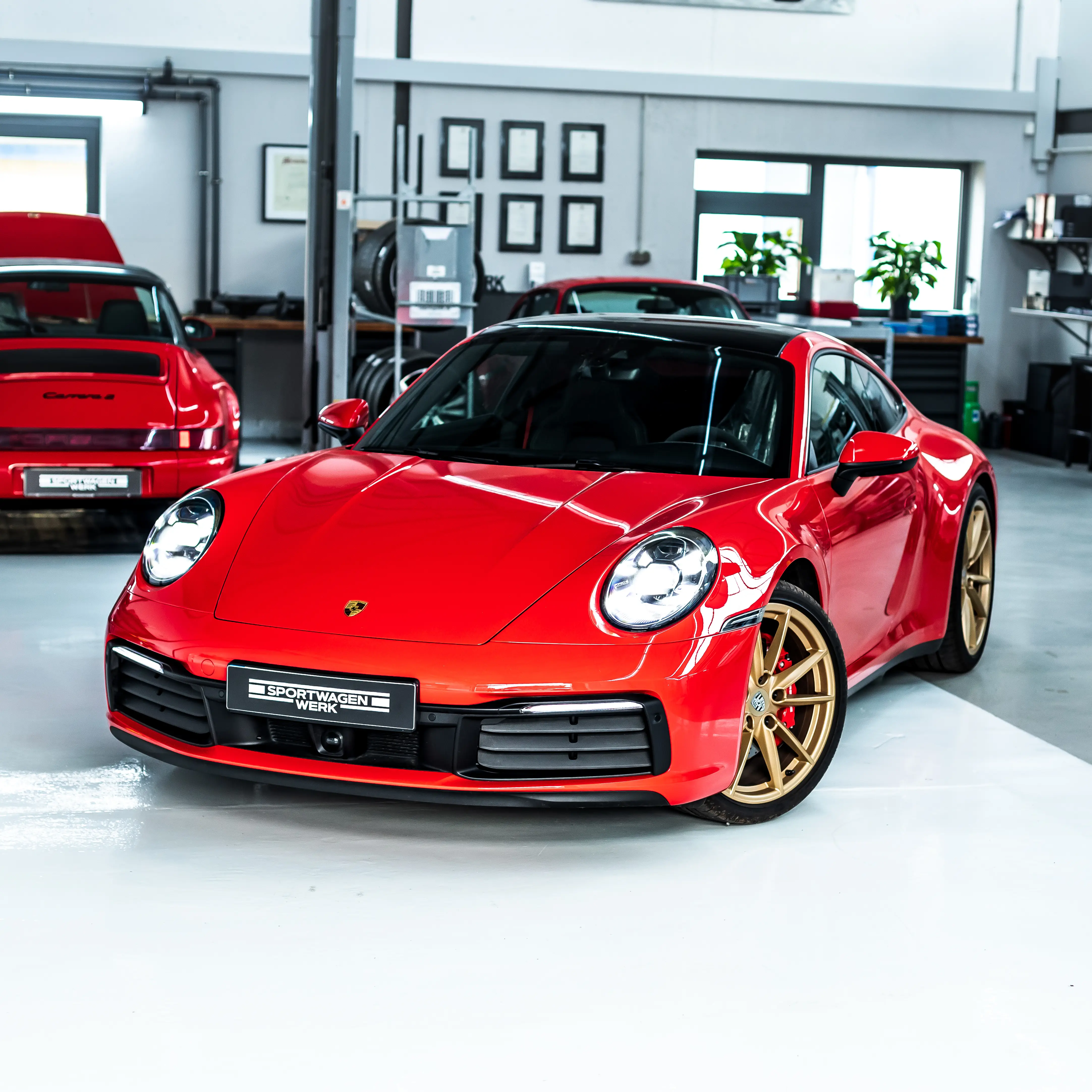 Porsche 992 Rubin rot mit goldenen Felgen bei Sportwagen Werk Neuss