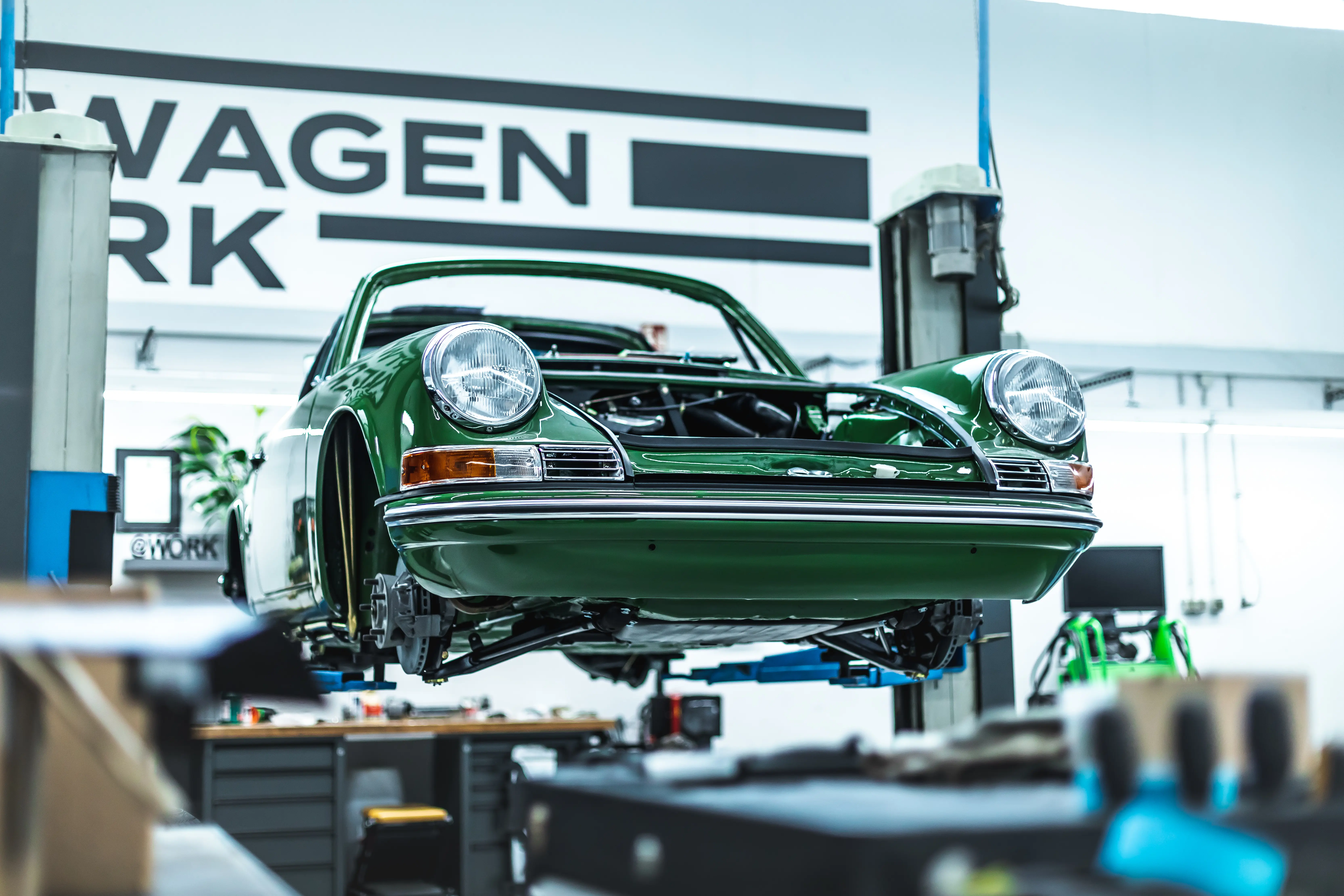 Porsche 911 Targa Smaragd grün auf Hebebühne frontal – Restauration Sportwagen Werk