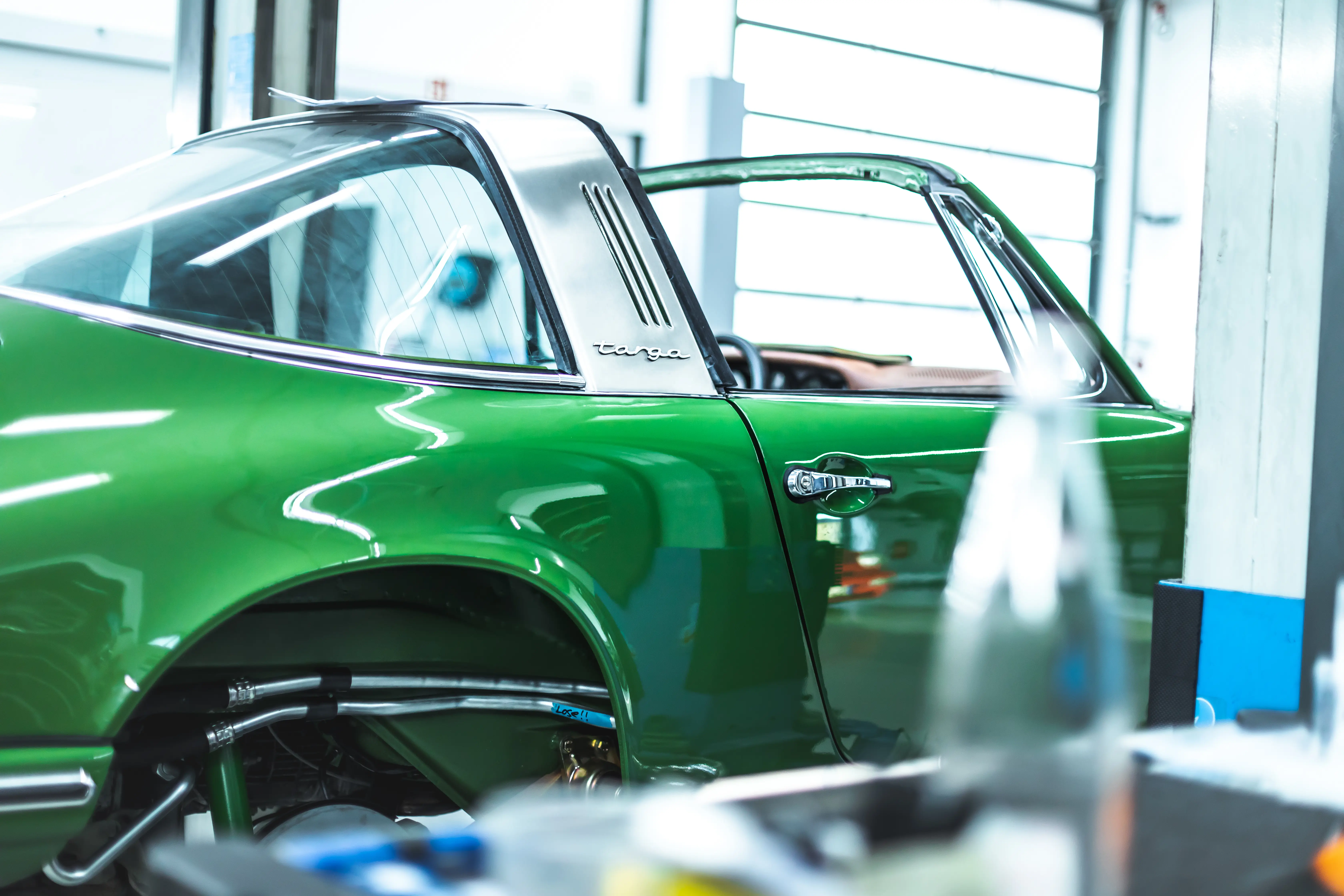Porsche 911 Targa Smaragd Seitenansicht mit Targa-Bügel in der Werkstatt